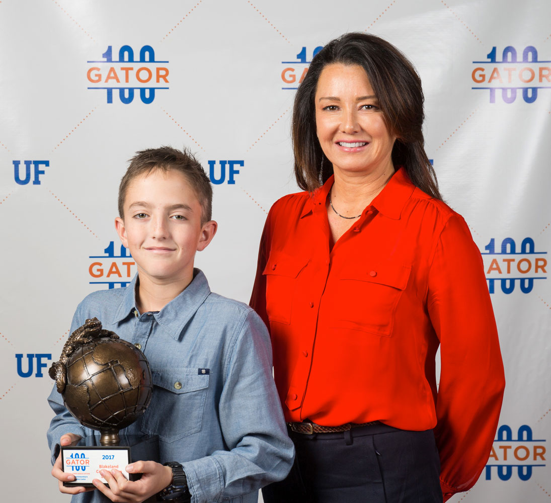 Photo of Cornwell and child with Gator 100 award